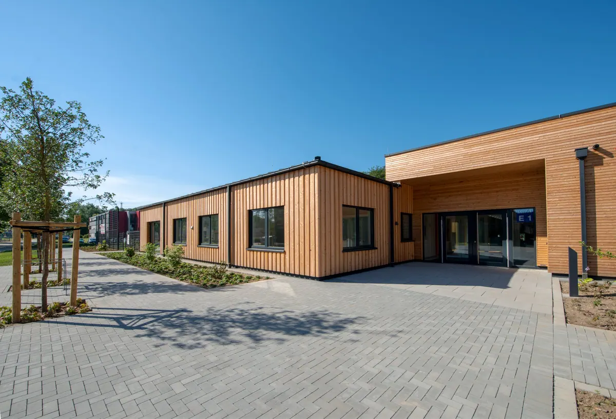 Eingangshof mit Holzfassade und bodentiefen Fenstern
