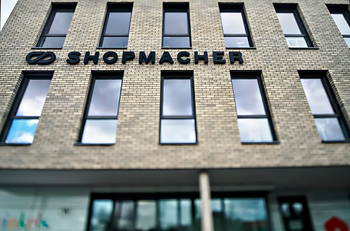 Fassadenausschnitt mit Klinker, Fensterreihen und Schriftzug