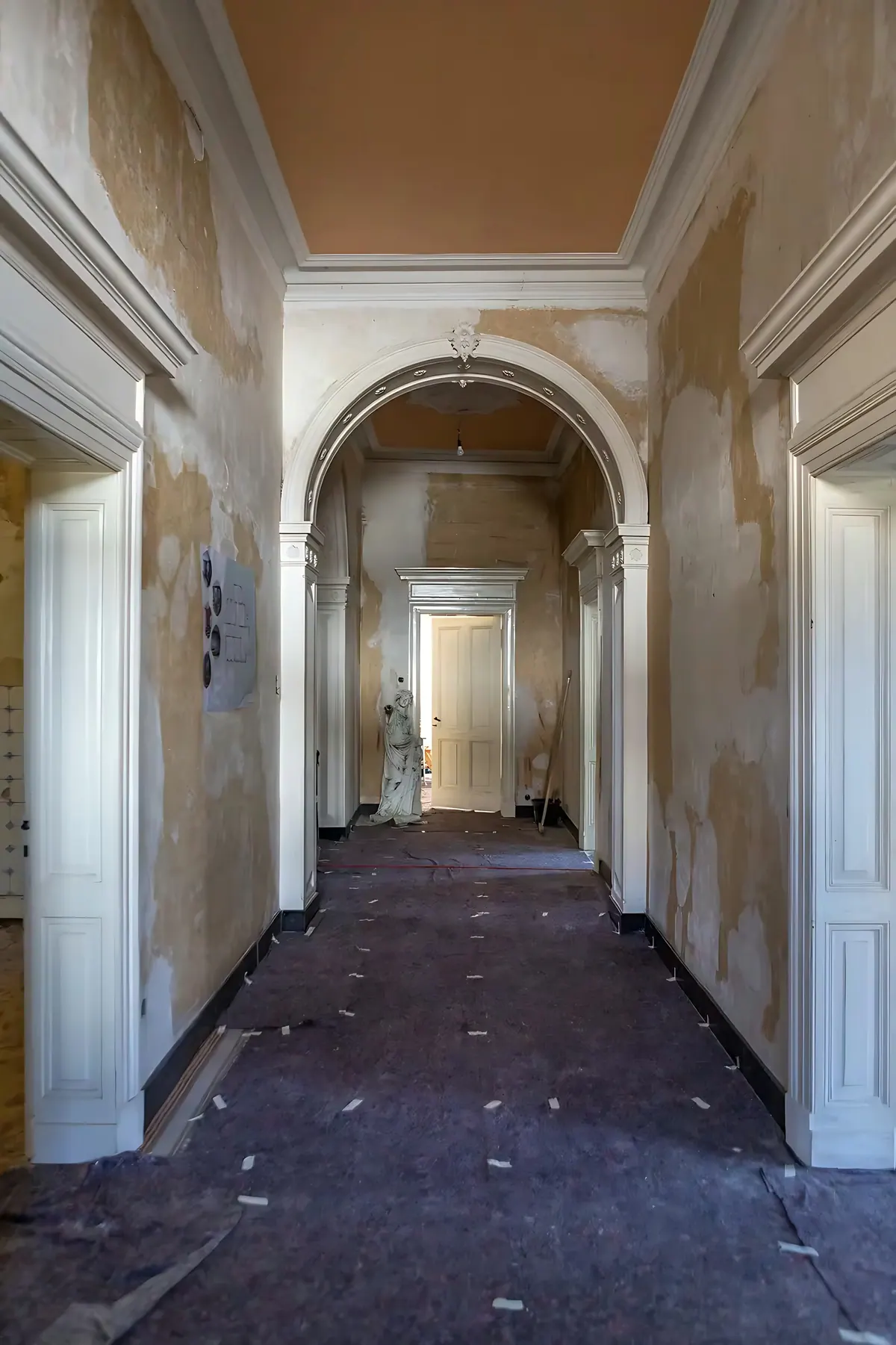 Voor de renovatie: gang met boogopeningen en oude tegelvloer