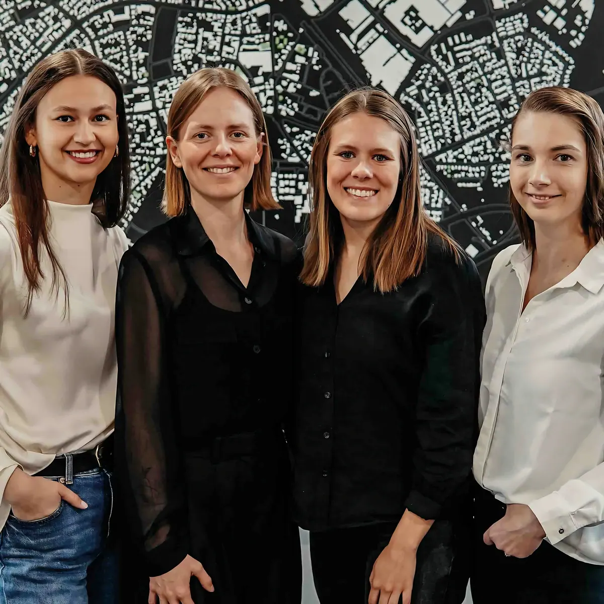Vier collega's van Hetkamp Architektur voor een stadsplattegrond op kantoor